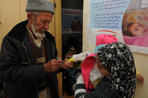 An Afghan man marks a child's hand after administering the polio vaccine during a visit to the Farah children's supplemental feeding center, Dec. 22.  Afghanistan is one of three country's in the world where active polio cases still exists.  Farah province has had one recorded case of polio in 2012.  PRT Farah's mission is to train, advise, and assist Afghan government leaders at the municipal, district, and provincial levels in Farah province, Afghanistan.  Their civil military team is comprised of members of the U.S. Navy, U.S. Army, the U.S. Department of State and the U.S. Agency for International Development (USAID).  (U.S. Navy photo by Lt. j.g. Matthew Stroup/released)